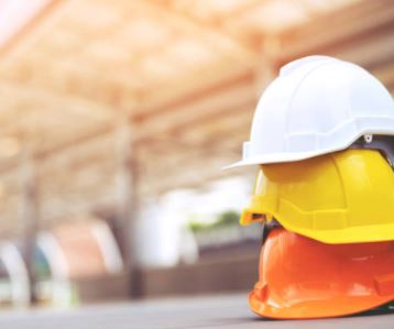 Three stacked construction hard hats.