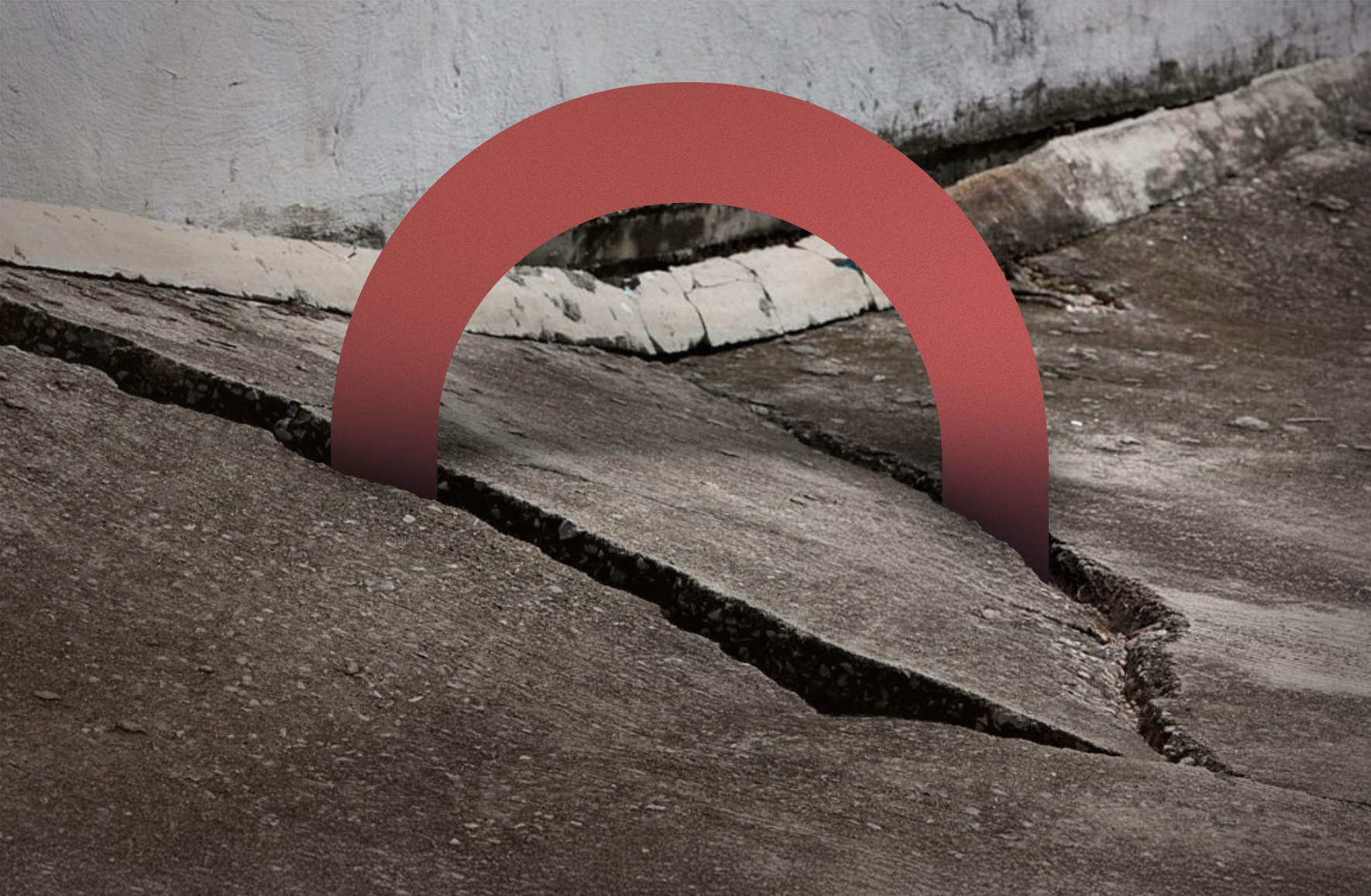 Uneven, cracked pavement where it meets the seam of a house wall